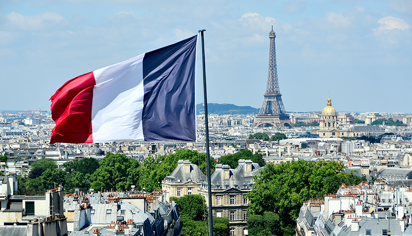 Frankreich legt vierte grüne Staatsanleihe auf, Frankreich-Flagge vor der Skyline von Paris